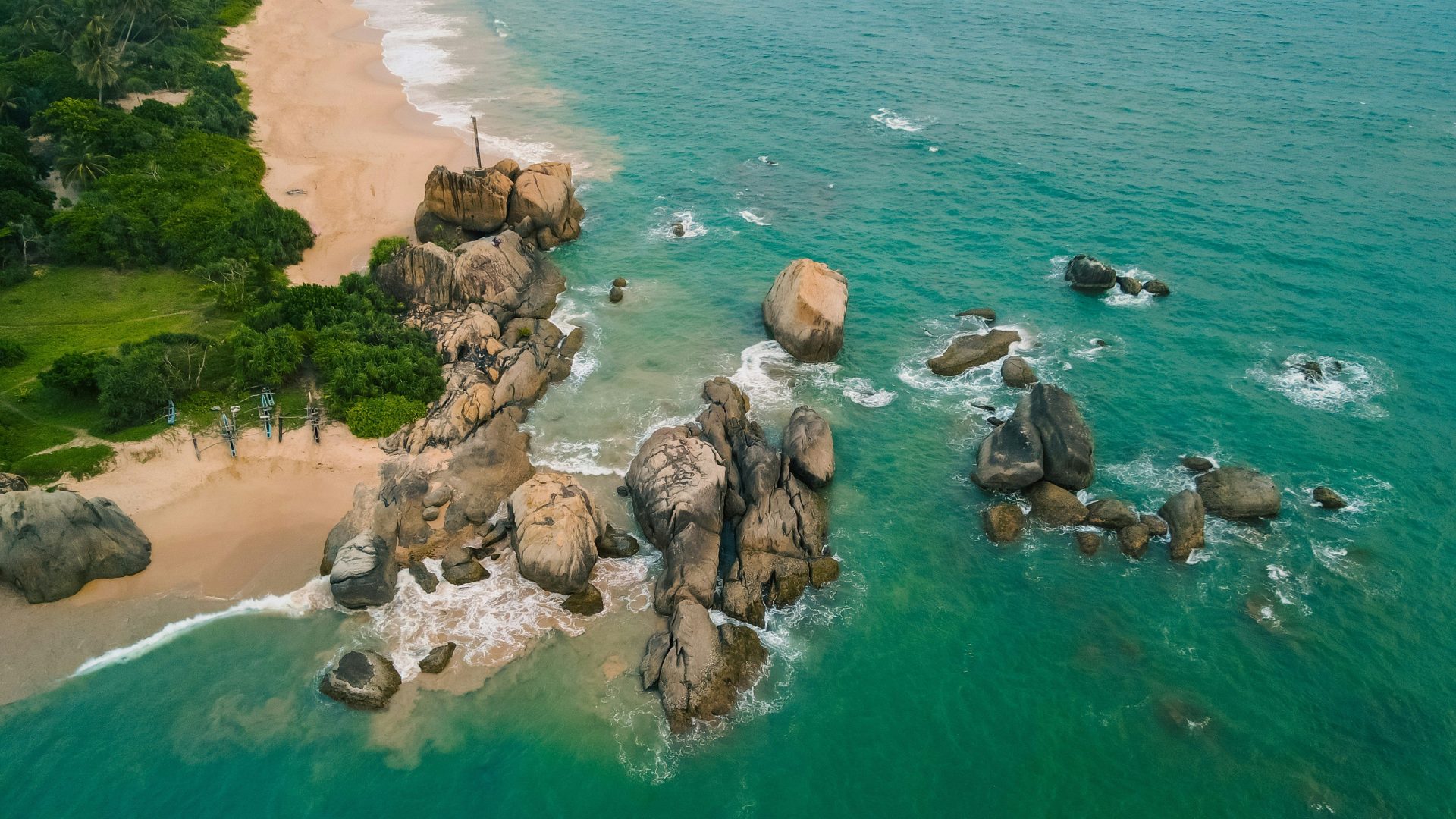 an aerial view of a beach with rocks and water